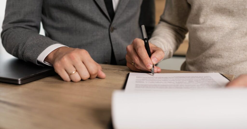 Deux personnes signant un document contractuel sur un bureau
